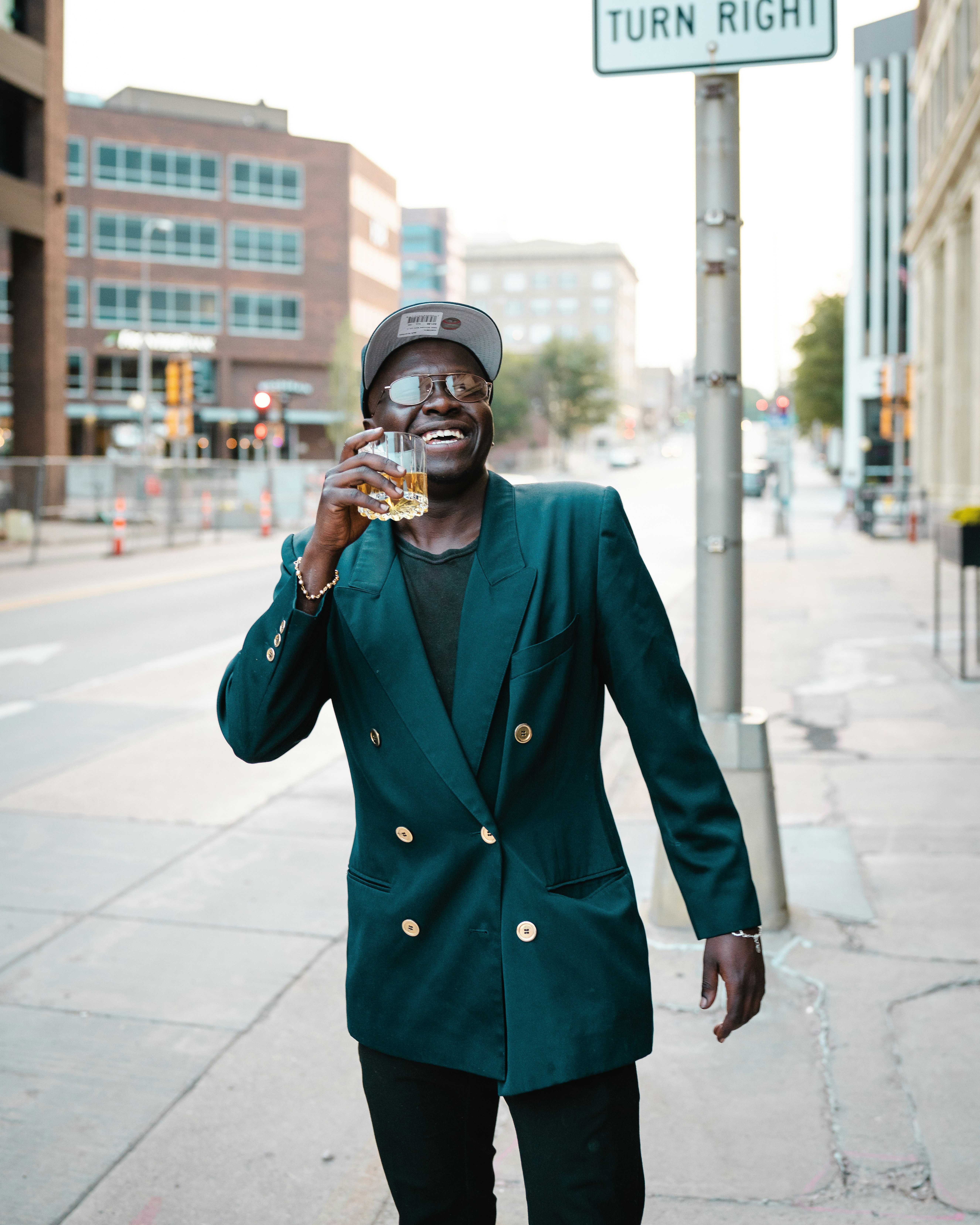 man in blue coat holding smartphone standing on sidewalk during daytime